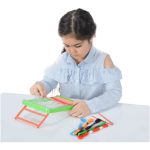 کودک در حال کوبلن‌دوزی روی پارچهٔ طرح‌دار؛ نخ‌های رنگی کنار دست